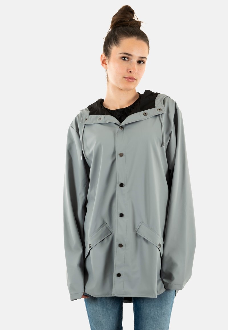 Giacca antipioggia grigio chiaro con cappuccio nero, chiusura a bottoni e tasche laterali. Realizzata in materiale impermeabile, presenta una vestibilità comoda e coulisse regolabili.