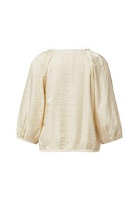 Kremowa bluzka o luźnym kroju, wykonana z teksturowanej tkaniny, z rękawami typu balon oraz marszczonym dołem zapewniającym swobodną sylwetkę.