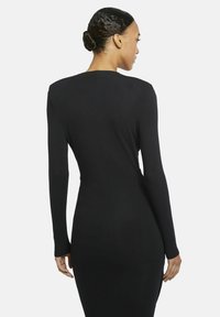 Schwarzes, langärmliges, tailliertes Kleid, glatte Textur, hoher Halsauschnitt, gerächter Rückennaht, reicht bis zur Mitte der Wade, einfaches Design ohne Verzierungen.