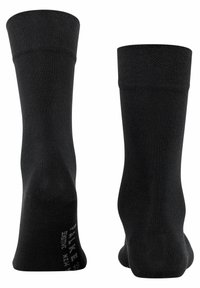 Calze di cotone nere con polsini a coste, texture liscia, tallone e punta rinforzati, e dettaglio del logo stampato sulla soletta.