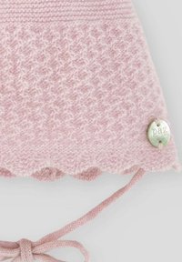 Bonnet en tricot rose avec un motif texturé, un bord festonné et une étiquette en argent portant le mot "paz". Liens pour un maintien sécurisé.