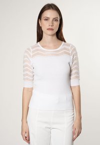 Weißes geripptes Strick-Top mit kurzen, durchsichtigen gestreiften Ärmeln und rundem Halsausschnitt. Weiche Textur mit figurschmeichelnder Silhouette.