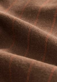 Brown textured fabric featuring thin orange stripes running horizontally. The fabric appears soft and smooth, with a slight sheen.