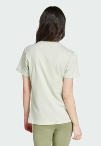 Camiseta de manga corta en verde claro con cuello redondo, hecha de algodón, que presenta una textura suave y un corte relajado.