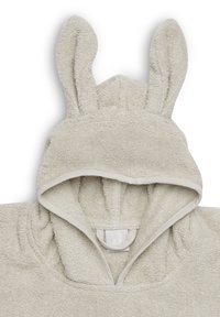 Serviette à capuche gris clair avec des oreilles de lapin, texture douce en éponge et une boucle au niveau du cou. Bord en tissu clair assorti.