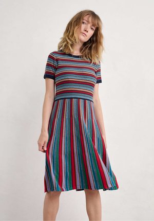 Gestreepte gebreide jurk met korte mouwen, met een aangesloten lijfje en een uitlopende rok. Kleuren zijn marineblauw, rood, groen en paars. Gestructureerde afwerking.
