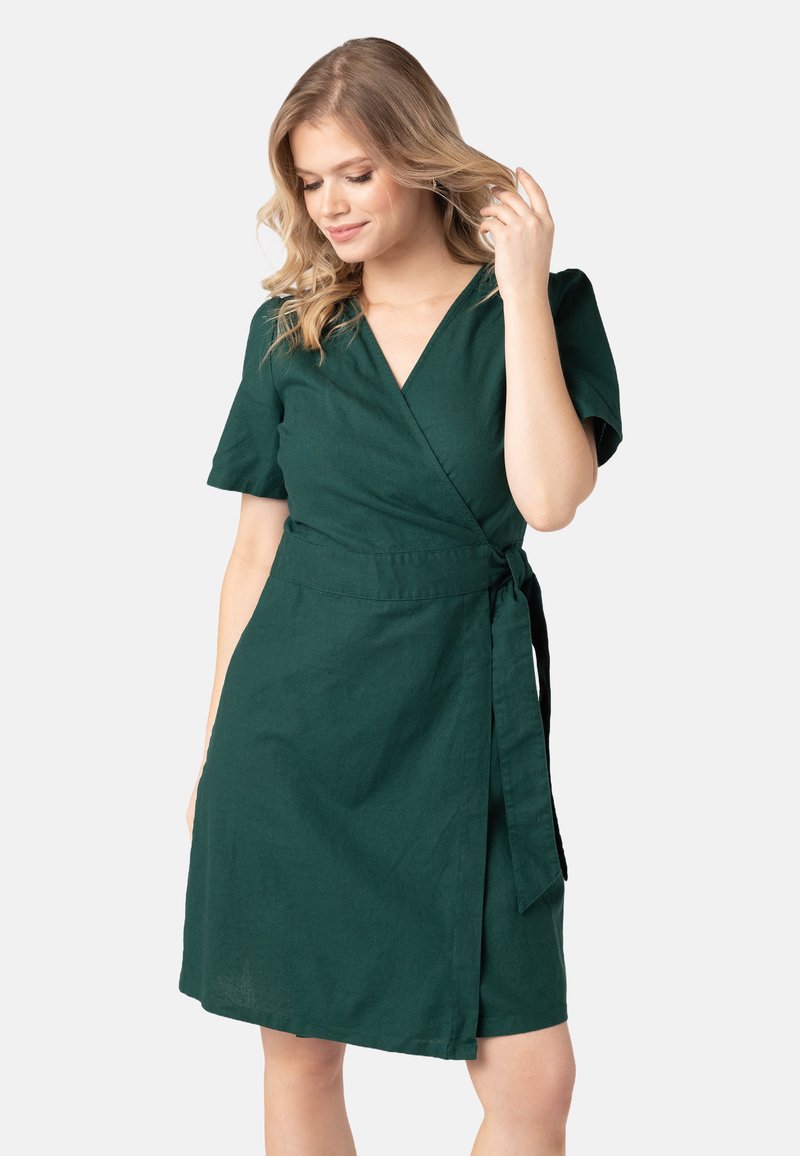 Groene wikkeljurk van geweven stof, met korte mouwen, een diepe V-hals en een strikriem in de taille voor een verstelbare pasvorm.