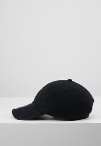 Gorra de béisbol de algodón negra con visera curva, diseño de seis paneles y acentos bordados en la parte delantera y lateral. Acabado de tela texturizada.