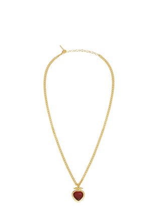 Collier chaîne en or avec un petit pendentif rouge en forme de cœur encadré d'or sur fond blanc.