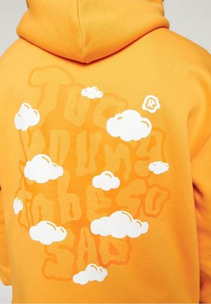 Sweat à capuche orange vif avec texte stylisé « True Young Embers Sad » partiellement recouvert d’illustrations de nuages blancs dans le dos.