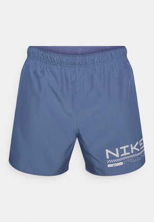 Zilas sporta šorti ar elastīgu jostasvietu. Kreisajā kājā ir balts Nike logotips un ģeometrisks raksts. Gluda, viegla auduma.