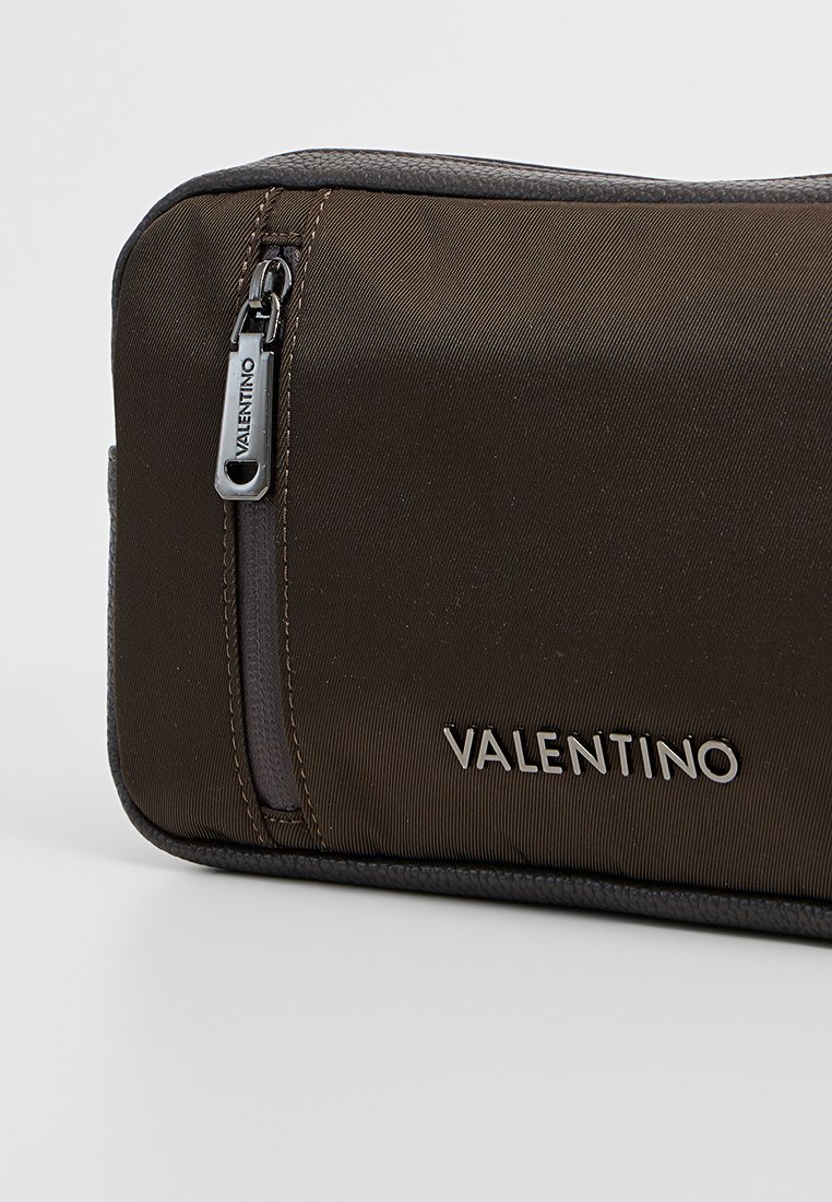 Funda de nailon marrón con cremallera, con acentos texturizados, que presenta un logo plateado de Valentino y una cremallera gris contrastante.