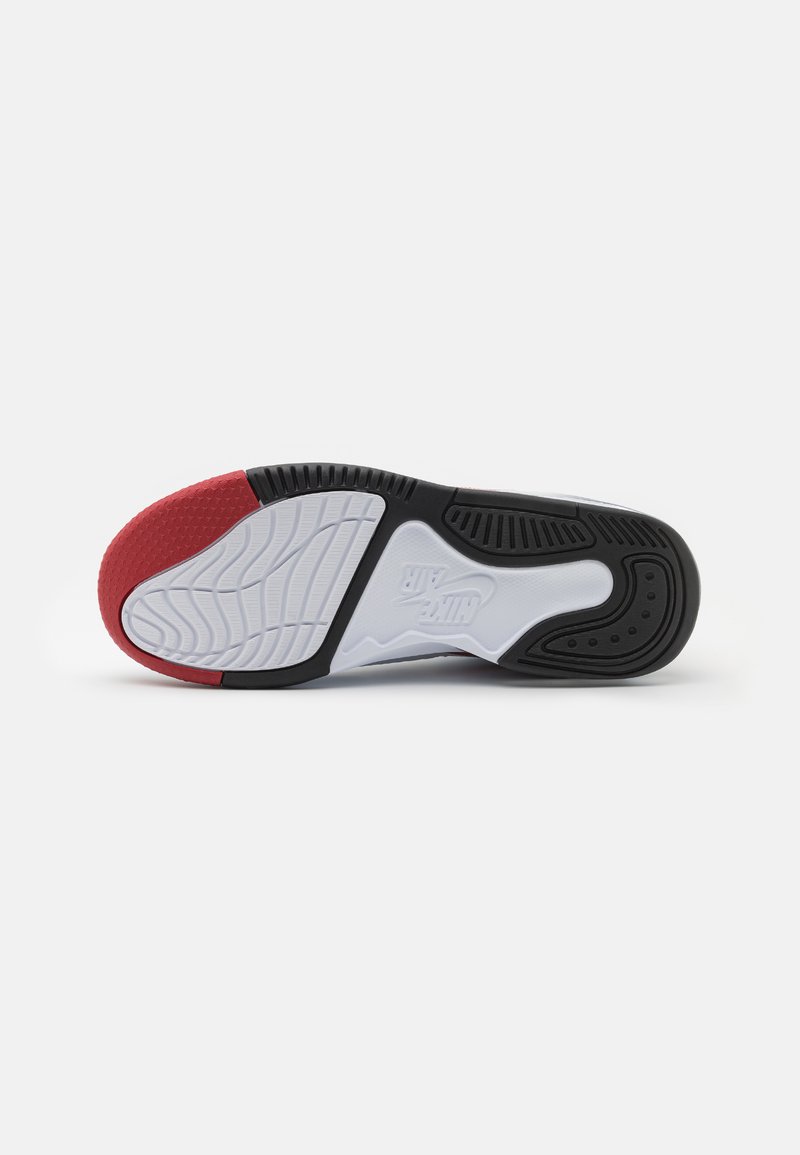 Suela de zapato con una base de goma y un centro texturizado en negro, acento rojo en el talón y una entresuela blanca con un patrón ondulado.