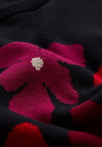 Schwarzer Strickpullover mit großen rosa und roten Blumenmustern, mit einer strukturierten Oberfläche und einem glatten, weichen Stoff.