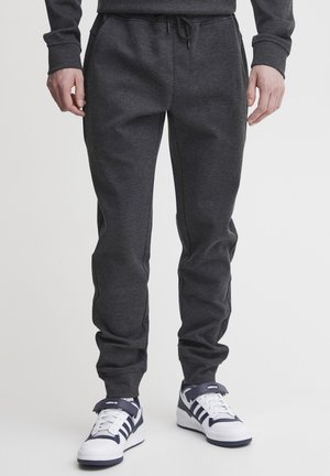 Dark gray jogger pants in soft fabric with a relaxed fit, featuring an elastic waistband with drawstring, side pockets, and tapered legs.