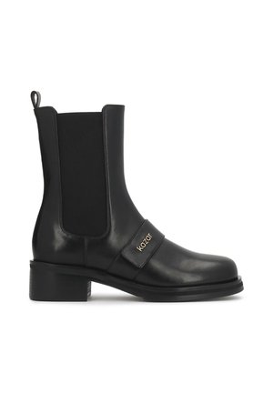 Bottine en cuir noir avec talon bloc, panneaux latéraux élastiques, languette arrière et une bride avec le nom de la marque Kazar sur le côté.