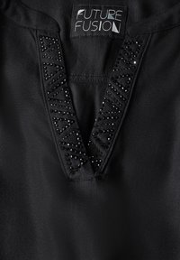 Top in tessuto nero con scollatura a V, caratterizzato da dettagli decorativi in perline e un motivo geometrico attorno allo scollo. Etichetta del marchio visibile.