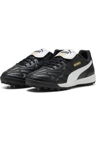 Botas de fútbol negras hechas de cuero sintético con acentos blancos, diseño con cordones, cuello acolchado y suela de goma texturizada para tracción.