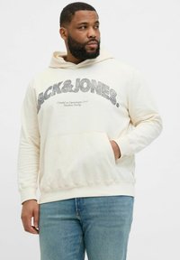 Kremowy hoodie z kieszenią z przodu, ściagaczami przy mankietach i haftowanym logo "JACK & JONES" w kolorze szarym, o komfortowym kroju.