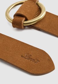Ceinture en suède brun avec le logo "Levi's" en relief et une boucle en laiton ronde sur une surface claire.