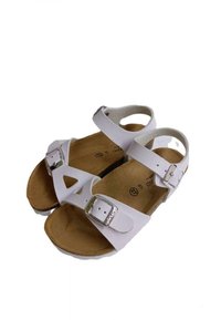 Sandali bianchi con cinturini regolabili e fibbie in argento. Suola in sughero con una texture liscia, caratterizzata da un design con ritagli nell'area delle dita.