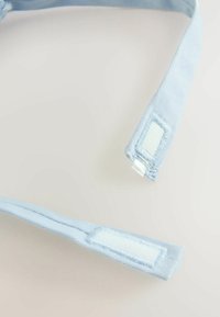 Cinghie in tessuto azzurro chiaro con una texture morbida, dotate di chiusure in velcro alle estremità, progettate per una chiusura regolabile.