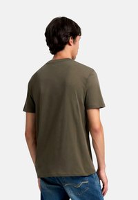 Oliven grøn kortærmet T-shirt lavet af blødt bomuld, med en klassisk rund hals og en afslappet pasform, vist fra ryggen.