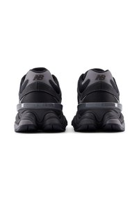 Μαύρα αθλητικά παπούτσια με υφαντό πλέγμα και σχέδιο από καουτσούκ, με αντανακλαστική ταινία στη φτέρνα και διακριτική λεπτομέρεια με λογότυπο.