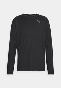 Černá košile s dlouhým rukávem vyrobená z lehké látky, s kulatým výstřihem a jemným logem na levé části hrudi. Hladká textura.