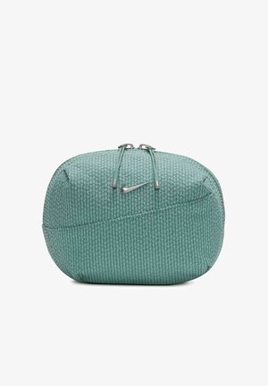 Mündroheline ristkülikukujuline kott, mis on valmistatud tekstuurilisest materjalist, millel on lukuga sulgemine hõbedaste detailidega ja väike Nike-logo.