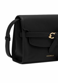 Borsa a tracolla in pelle nera con una forma strutturata, chiusura a gancio e dettagli in metallo dorato. Logo impresso sul davanti.