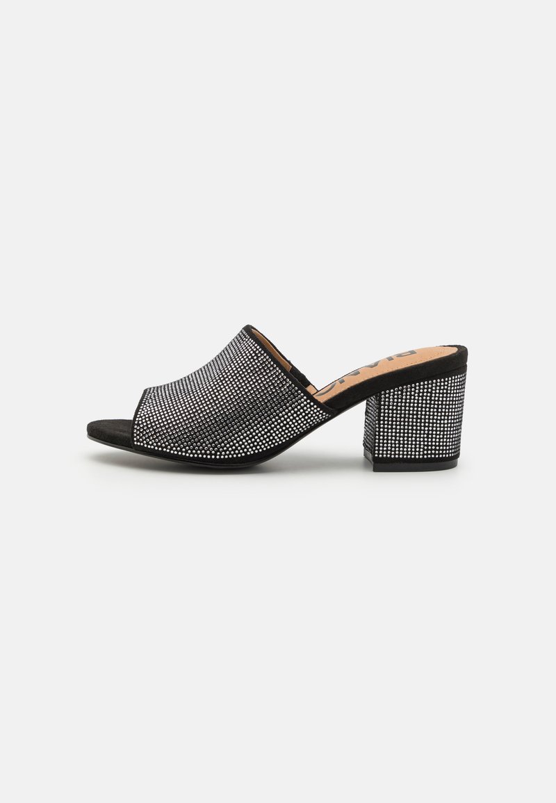 Mule noir à bout ouvert avec un dessus texturé orné de clous en argent, présentant un talon bloc et une doublure intérieure lisse.