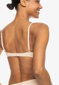 Beige geruite bralette met verstelbare spaghetti-bandjes en een haaksluiting op de rug, met een textuurstof en gevoerde accenten.