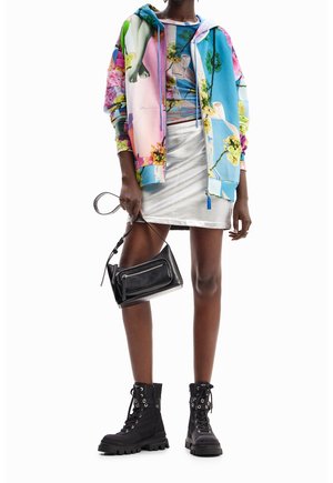 Sudadera con capucha colorida con estampados florales, top corto ajustado, falda metálica plateada, bolso negro y botines con diseño de cordones y suela gruesa.