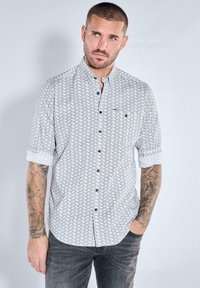 Kurzärmeliges Hemd in hellgrau mit strukturiertem Muster. Verfügt über eine geknöpfte Vorderseite, einen mittleren Kragen und schwarze Knöpfe. Wird mit dunklen Jeans getragen.