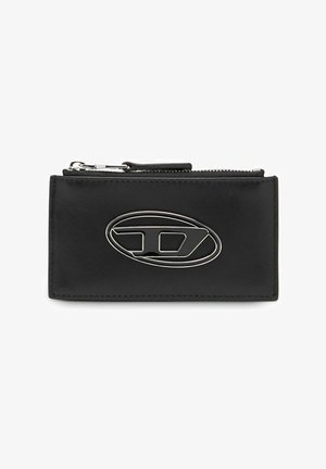 Musta nahkalompakko, jossa on hopeinen ovaali logo, vetoketjukiinnitys ja ommellut reunat. Kompakti suorakulmainen muoto.