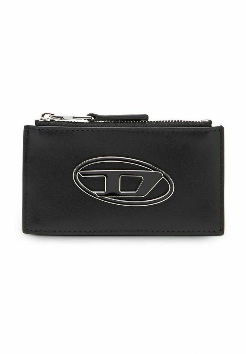 Cartera de cuero negro con un logo ovalado plateado, con cierre de cremallera y bordes cosidos. Forma rectangular compacta.
