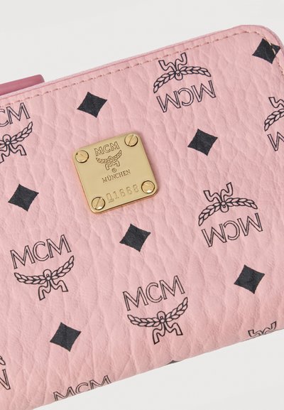 Ροζ πορτοφόλι με υφή και επαναλαμβανόμενα μαύρα λογότυπα MCM και διαμάντια, με χρυσή τετράγωνη πλακέτα της μάρκας MCM München με τέσσερις βίδες.