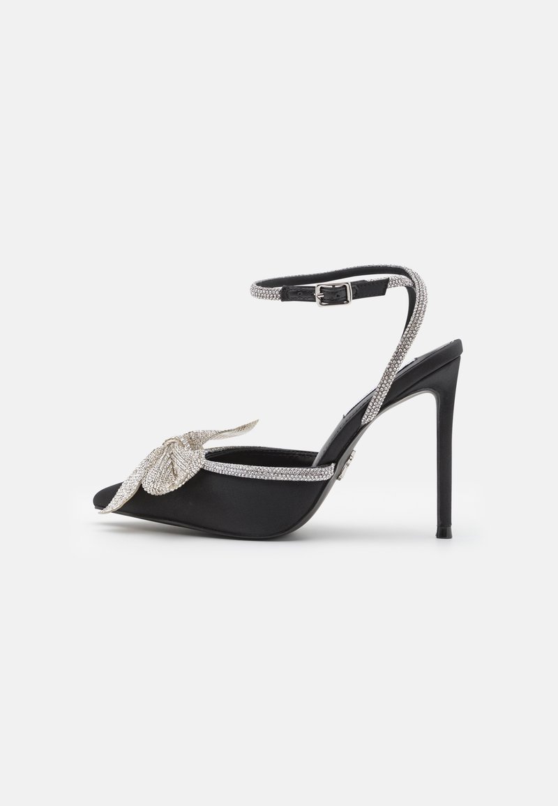 Sandale noire à talon haut avec bride à la cheville et bride à l'orteil ornées de strass étincelants et décorée d'un nœud orné de cristaux.