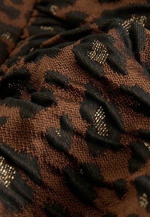 Hnědá a černá texturovaná tkanina s vyvýšeným vzorem leopardího tisku a metalickými akcenty, zobrazující složité detaily tkaní.
