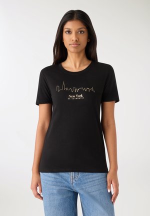 T-shirt nera in cotone con grafica dorata dello skyline di New York e testo "BE AUTHENTIC" sotto. Maniche corte e scollo rotondo.