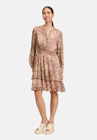Durchsichtiges Kleid mit Animal-Print in Beige- und Brauntönen, mit einem knöpfbaren Ausschnitt, elastischem Taillenbund und gestuften Rüschenschichten.