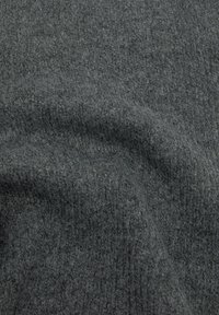 Grå tekstureret stof med en blød, fuzzy finish og et subtelt rillemønster. Materialet virker varmt og hyggeligt.