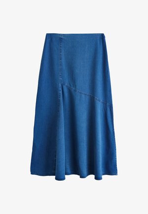 Sinine teksase midi-seelik asümmeetriliste õmblusdetailide ja lehviva äärega, valge tausta ees.