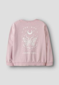 Sweatshirt rose en tissu doux, avec un graphique blanc d'un papillon, de lunes et d'étoiles. Texte "COSMIC VIBES" en bas.