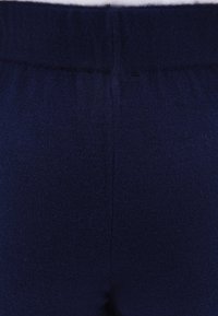 Marineblauwe gebreide stof, met een zachte textuur, elastische tailleband en een gladde afwerking. Het ontwerp is naadloos zonder zichtbare naden.