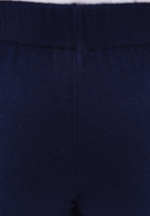 Tmavě modrá pletená látka, která má měkkou texturu, elastický pas a hladký povrch. Design je bezešvý, bez viditelných švů.