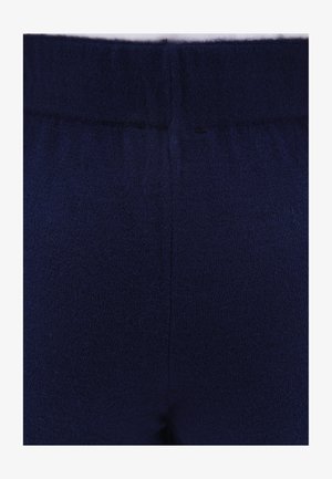 Granatowy dzianinowy materiał, charakteryzujący się miękką teksturą, elastycznym paskiem w talii i gładkim wykończeniem. Projekt jest bezszwowy, bez widocznych szwów.