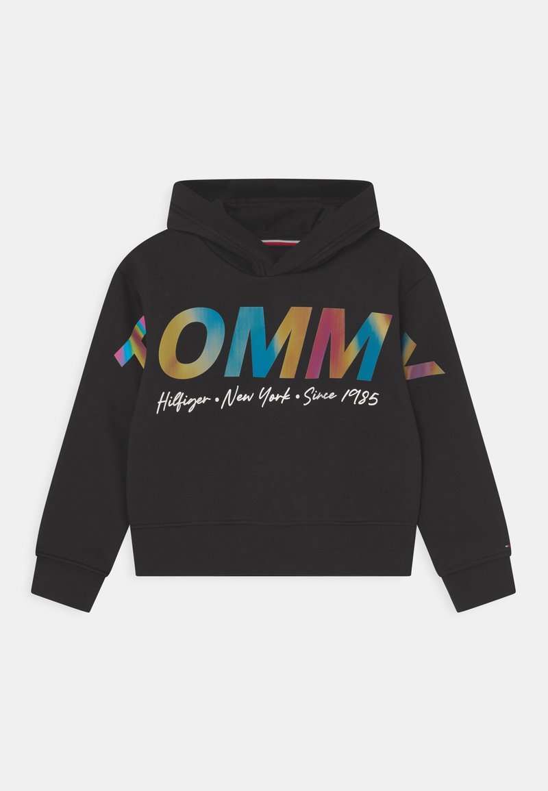 Sweat à capuche noir court avec le lettrage coloré "TOMMY" sur la poitrine et les manches, et le script blanc "Hilfiger New York Since 1985" en dessous.