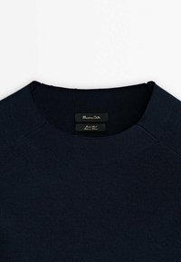 Laivastonsininen neulottu neulepaita, jossa on pyöreä pääntie, hienovarainen pintakuvio ja kauluksen sisäpuolella oleva Massimo Dutti -etiketti.